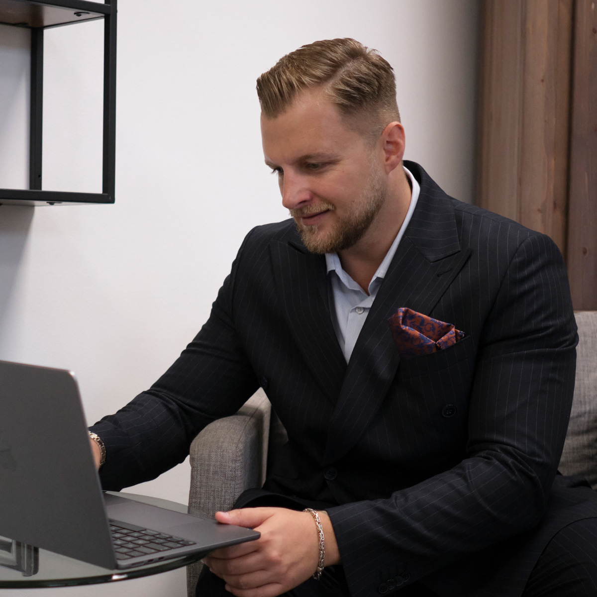 Makler im Anzug arbeitet am Laptop. Über uns erfahren Sie mehr. Kompetente Beratung.