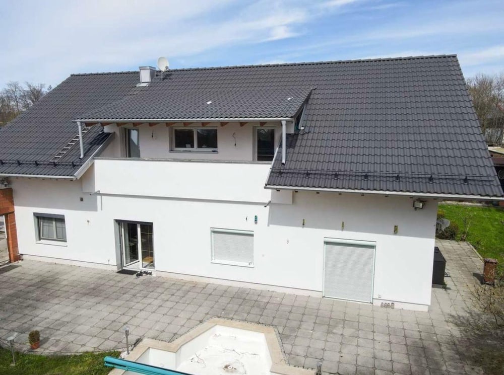 Isarnova Immobilien: Modernes Haus mit grauen Dachziegeln und großem Garten. Perfekt für Familien!