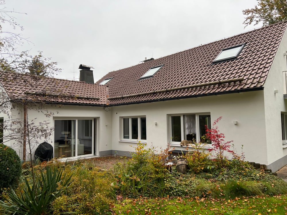 Isarnova Immobilien: Haus mit Garten. Gepflegtes Einfamilienhaus mit roten Dachziegeln und weißen Wänden.