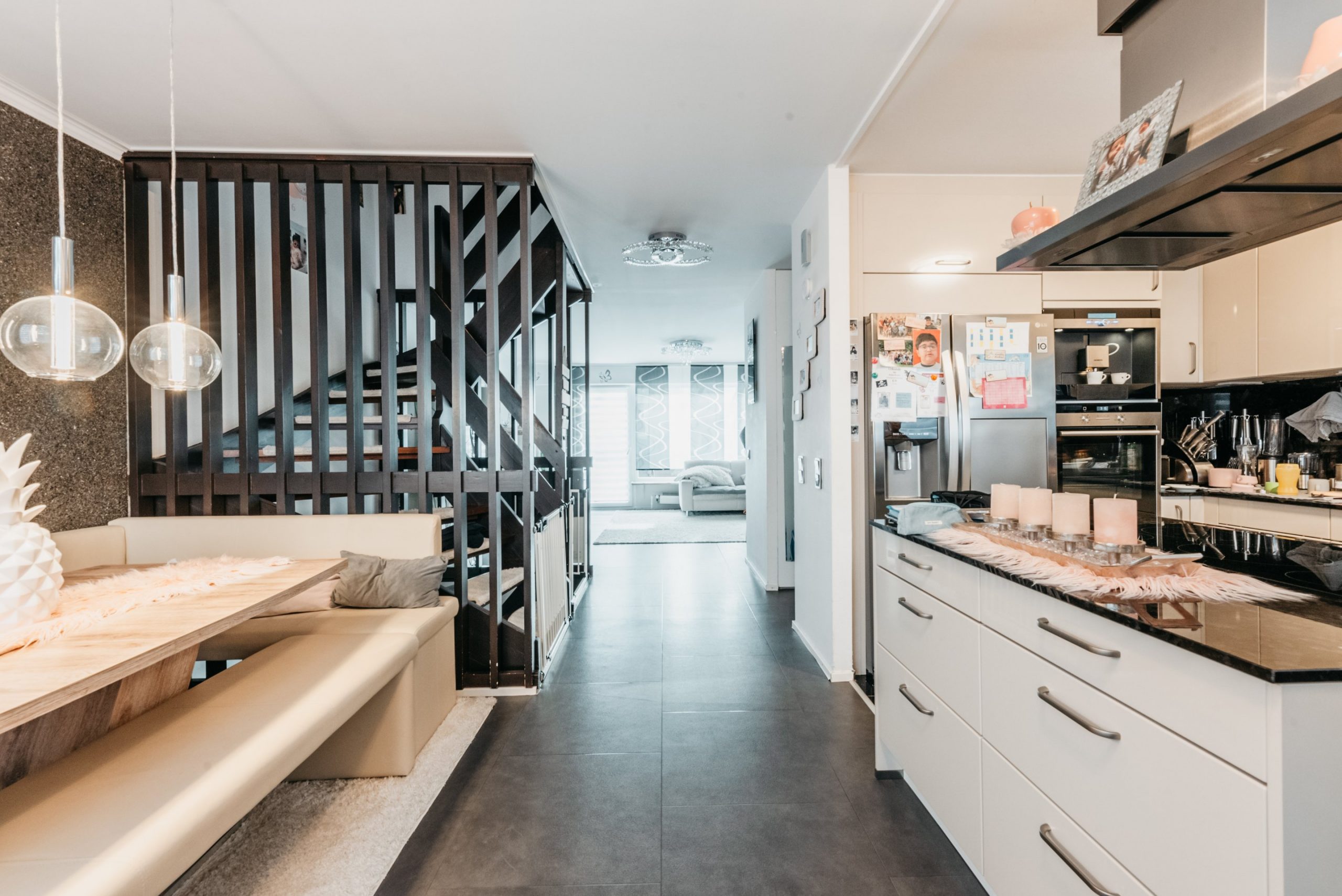 Isarnova Immobilien: Moderner Wohnbereich mit Treppe, Küche und Essbereich. Gepflegtes Interieur.